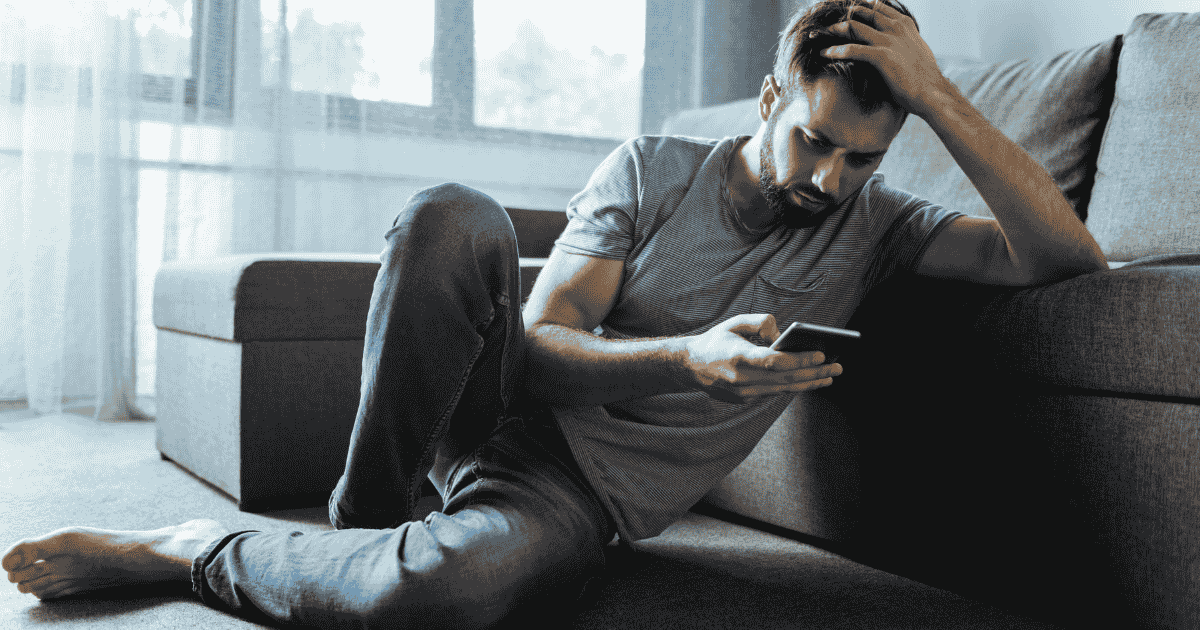 A man sad on his phone from being rejected